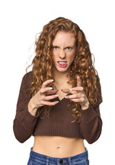Simple redhead studio portrait upset screaming with tense hands.