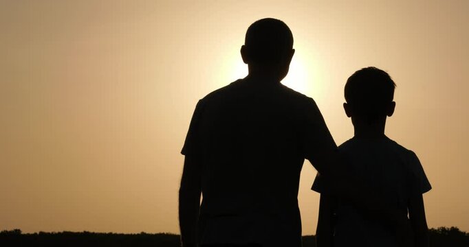 Support between father and teenage son captured in emotional close-up. Support expressed through sunset embrace shows deep connection and trust. Support defines powerful family moment.