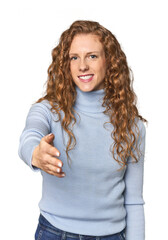 Simple redhead studio portrait cheerful and confident showing ok gesture.