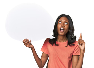 Indian woman with dialogue bubble pointing upside with opened mouth.