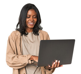 Cheerful young Indian woman holding a laptop in a studio setting