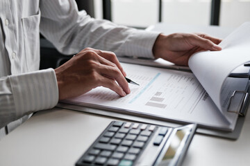 Financial admin reviewing printed data at worktable in professional office