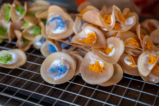 Colorful Khanom Buang, known as Thai crepe or crispy pancake with creamy topping made from egg whites and topped with egg yolk threads. It is a popular street food.