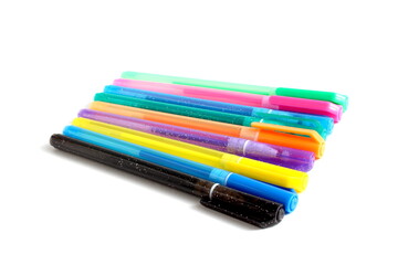 Fototapeta premium There are many multi-colored pens lying on a white background.