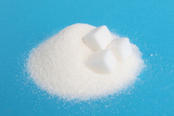 There are cubes of refined sugar lying on a pile of granulated sugar.	
