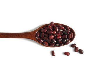 On a white background lies a wooden spoon with red beans.	