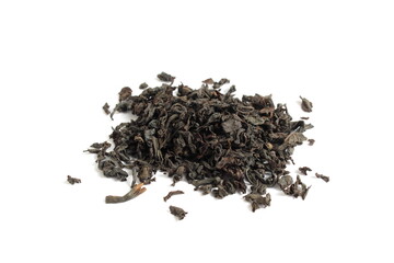 Dry tea leaves lie in a pile on a white background.	