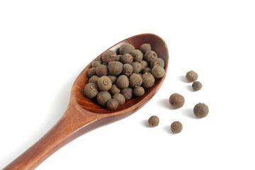 On a white background lies a pile of allspice peas.
