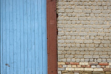 Altes großes Hoftor in Blau neben altem altem unverputzten Mauerwerk eines Wohnhaus und Bauernhaus...