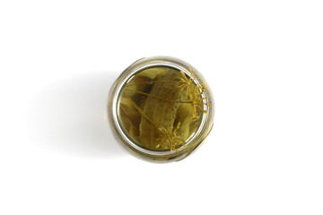 There is a glass jar with pickled cucumbers on a white background.	
