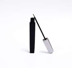 A sleek black eyeliner tube with a silver cap, featuring a thin applicator brush.