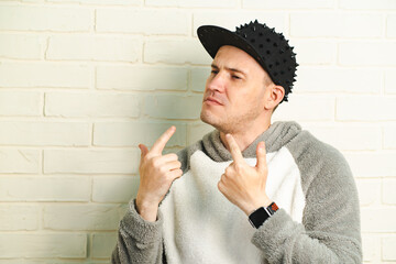 A man wearing a black cap and a gray sweater is captured in motion, dancing gracefully with fluid...