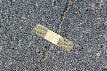 The crack in the asphalt was sealed with adhesive tape.