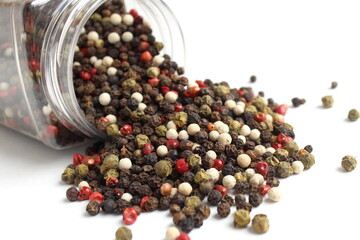 An assortment of hot peppers spilled out of a transparent container.