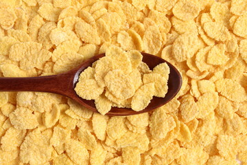 Wooden spoon with crispy yellow flakes.	