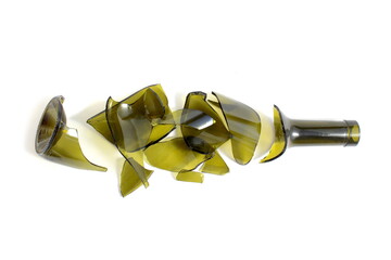 There is a broken green wine bottle lying on a white background.	