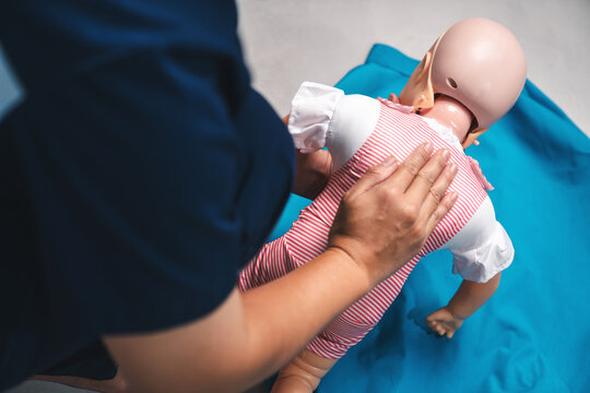 Pediatric First Aid, Infant Choking Rescue with Back Blows on Baby Manikin Demonstrated in Emergency Training Class