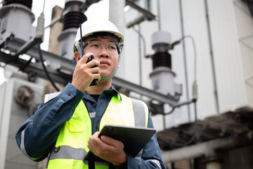 Power substation staff engineer work with radio communication and tablet in industrial electrical...