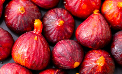 Figs close-up. Heap of figs, whole fruits and cut in half. Sweet exotic fruit for dessert, healthy food.