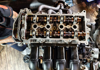 A car engine is being worked on inside a garage workshop