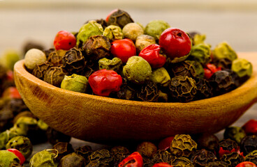 Peppercorns on a wooden background.