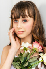 Little pretty girl in pink holds the bouquet of roses.