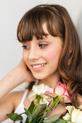 Little pretty girl in pink holds the bouquet of roses.
