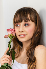 Little pretty girl in pink holds the bouquet of roses.