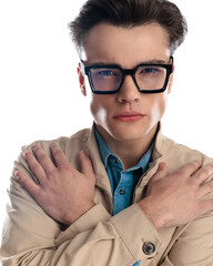 portrait of attractive young man with glasses holding hands on shoulders