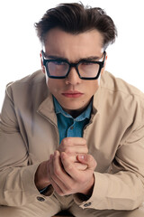serious young man with glasses looking forward and frowning