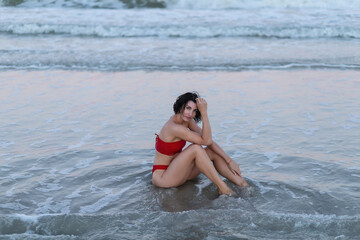 Sexy back of a beautiful woman in red bikini on sea background