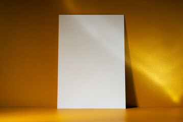 White Paper on Shiny Golden Background with Sunlight Reflections