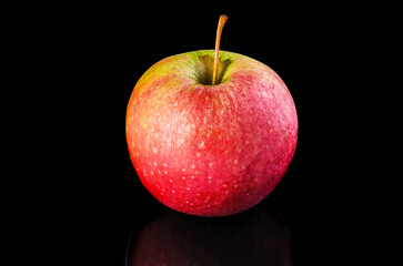Red Green Apple. A fresh red and green apple, rich in vitamins, on a dark background.
