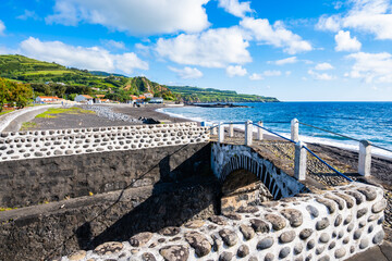 Coastal promenade along Almoxarife beach with azure ocean water, Faial island, Azores, Portugal