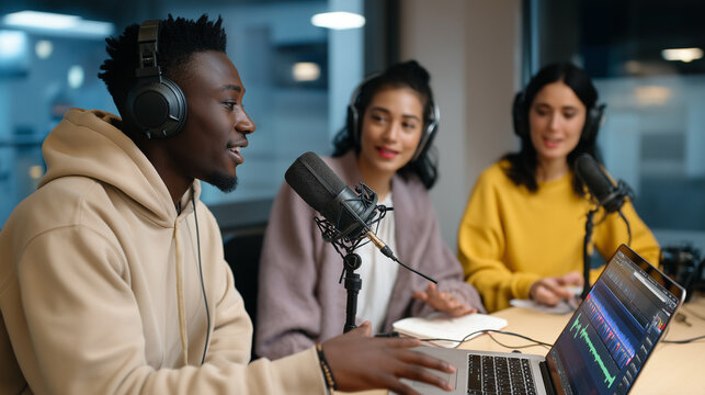 Three diverse young adults recording a podcast in a modern studio with microphones and headphones.
