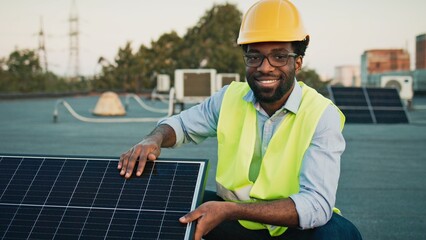 African American young happy man smiling confidently, demonstrating solar panel functionality,...
