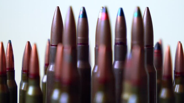 Different types of different types of bullets close-up rotating on white background, shallow depth of field