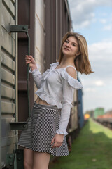 Portrait of a young beautiful blonde girl on the railway.