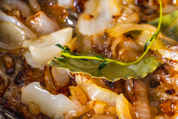 The onion is fried in a pan. The process of cooking onion soup. Caramelization of onions
