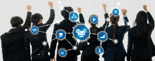 A diverse business team stands with raised fists in celebration, showcasing unity and motivation. Digital icons symbolize collaboration and innovation in the workplace. Amity