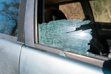 Shattered side car window, remaining glass visible, seats exposed, burglary or break-in aftermath, insurance claim evidence, vehicle crime concept, personal safety concern