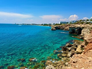Picturesque beach, waves crashing on the sandy shore. Sea waves beat against the rocks. Cyprus Island, Mediterranean Sea.