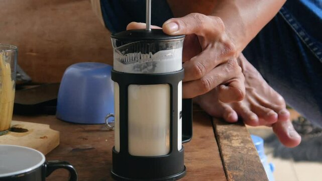 Stirring the milk coffee drink using a French press