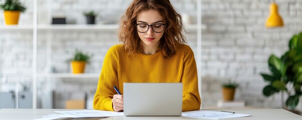 Coworking spaces, shared office and productivity, Young woman in glasses working on a laptop at a desk in a bright, modern home office with plants and shelves in the background.