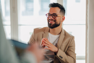 Smiling businessman listening attentively during meeting in office