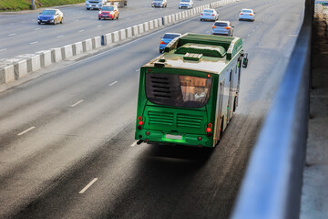 Bus and cars are moving along the road