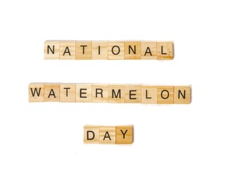 Wooden letter blocks spelling “National Watermelon Day” on white background. Clean minimal style for seasonal holiday celebration and summer-themed content.