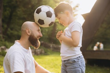 Father and son playing with soccer ball celebrating father's day