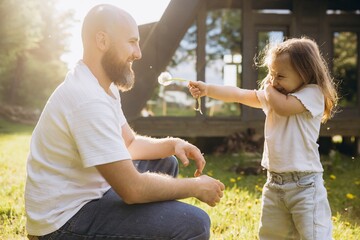 Daughter surprising father with dandelion on Father's Day