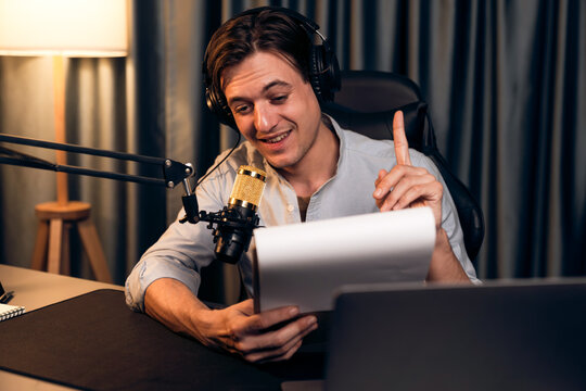 Host channel in smart broadcaster with talking show on live social media streaming with script note reading to listener with record video streamer in warm light night time at modern studio. Pecuniary.